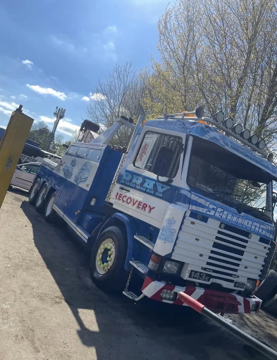 Blue and white Scania recovery truck after a wash